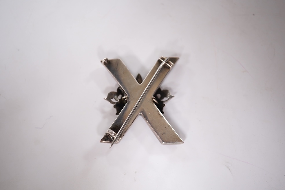 A late Victorian white metal and Scottish hardstone set 'X' brooch with coronet, 34mm, together with a silver hinged bangle and a George V silver mounted handbag mirror, with Reynold's Angels decoration. Condition - poor